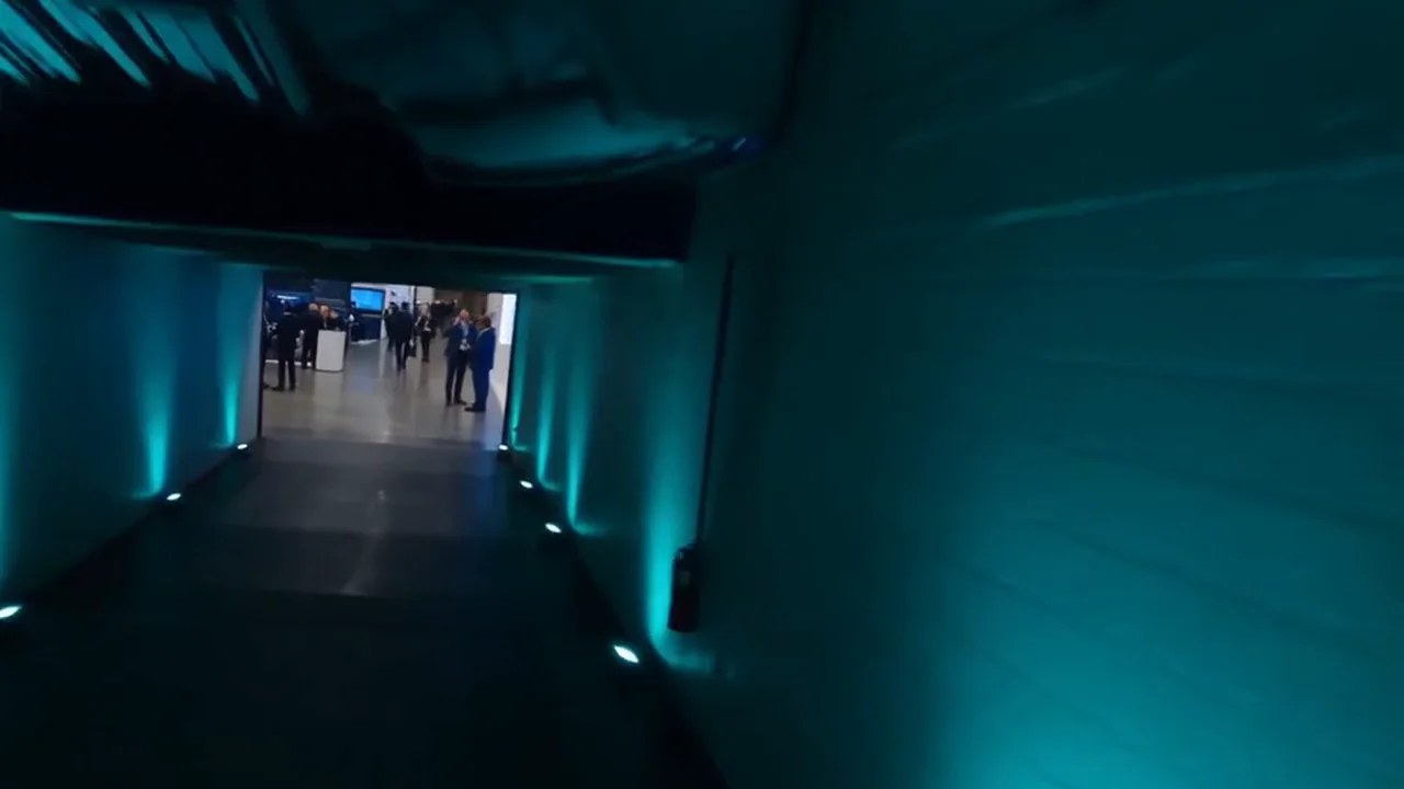 Teal-lit event corridor leading into a busy convention floor