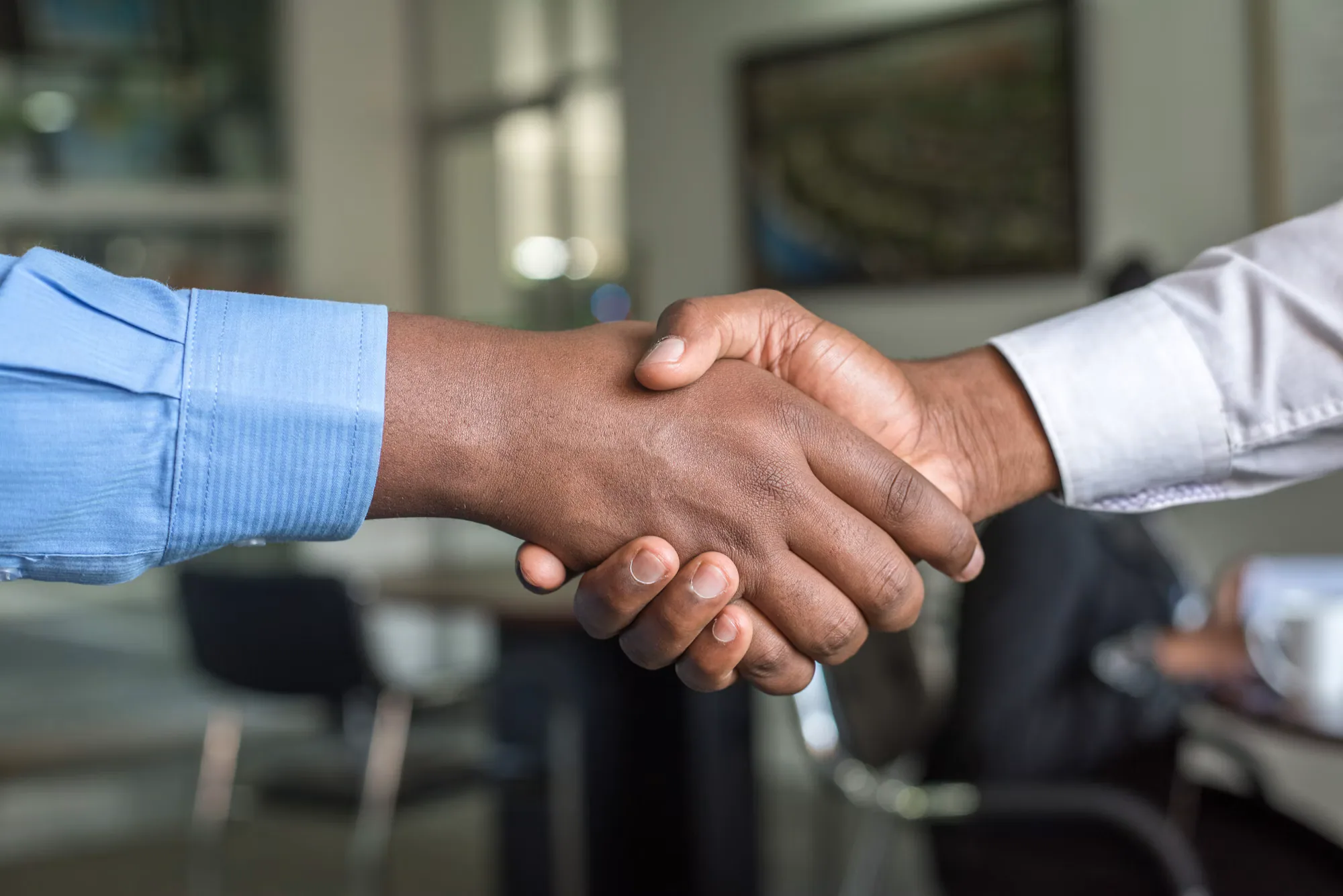 Two staffing partners shaking hands after reviewing compliance responsibilities
