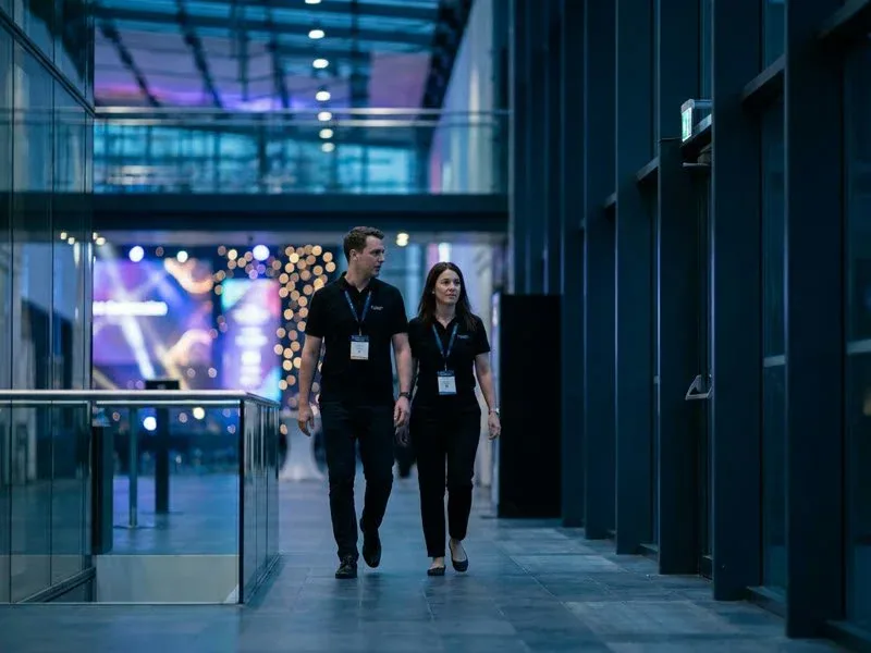 Two event staff walking through a convention center between assignments
